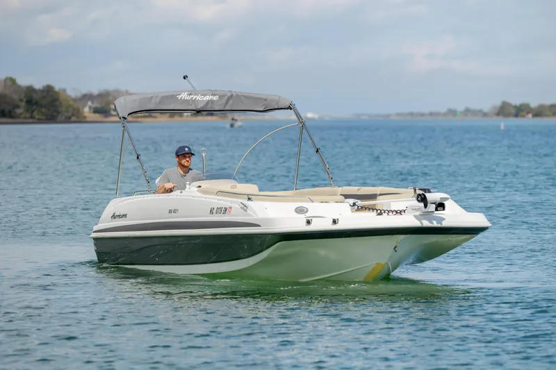 Slide: The Image of 2019 Hurricane SunDeck Sport 201 OB boat cruising on a serene lake. - 7