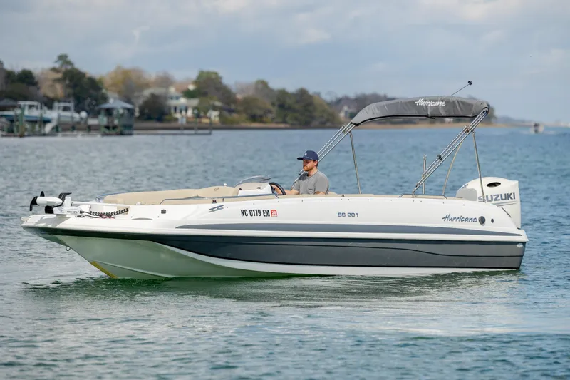 Slide: The Image of 2019 Hurricane SunDeck Sport 201 OB boat cruising on a calm lake. - 9
