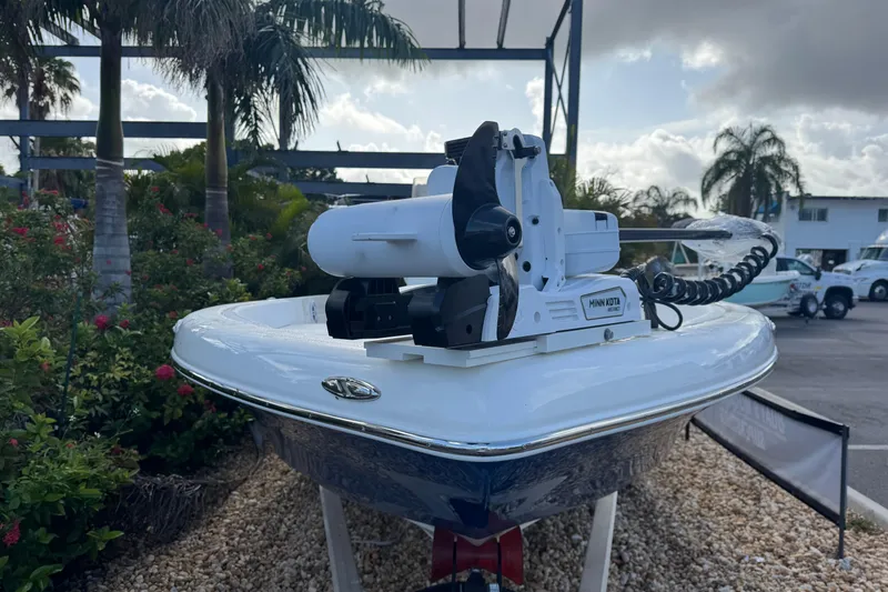 Slide: The Image of 2025 Skeeter SX2350 boat with Minn Kota motor, displayed outdoors with palm trees. - 4