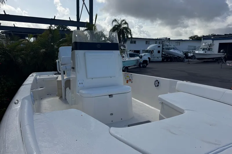 Slide: The Image of 2025 Skeeter SX2350 boat interior at a marina with parked boats and trucks. - 7