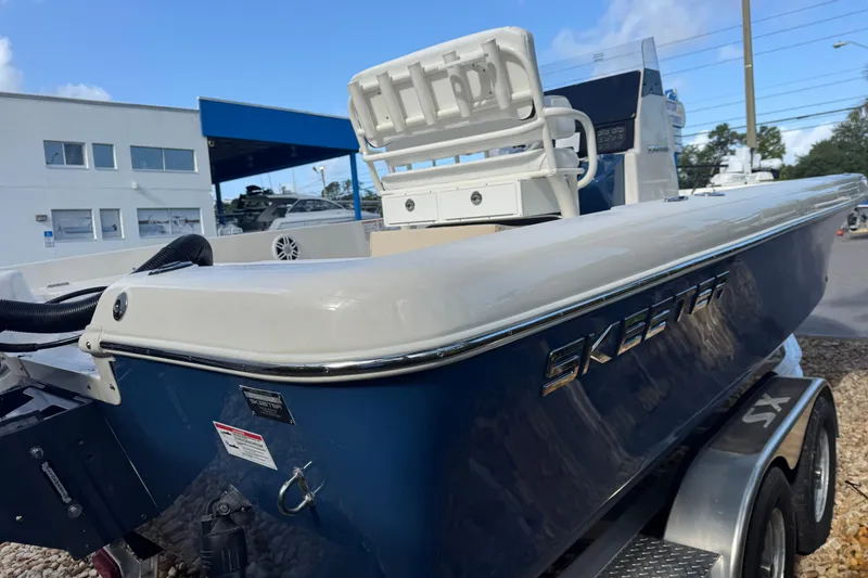 Slide: The Image of 2025 Skeeter SX2350 boat on trailer, blue hull, outdoor dealership setting. - 9