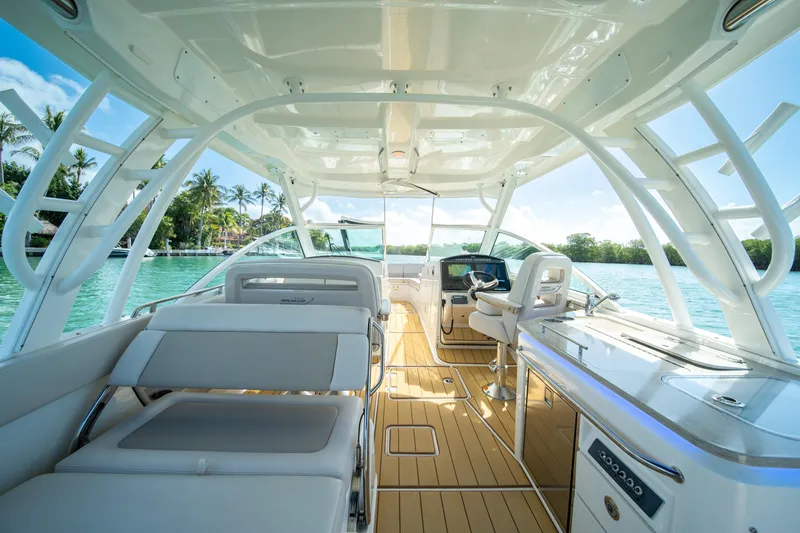 Slide: The Image of 2018 Boston Whaler 320 Vantage boat interior with luxurious seating and helm, on a sunny day. - 12