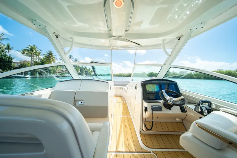 Slide: The Image of 2018 Boston Whaler 320 Vantage boat interior with helm, sunny waterfront view. - 14