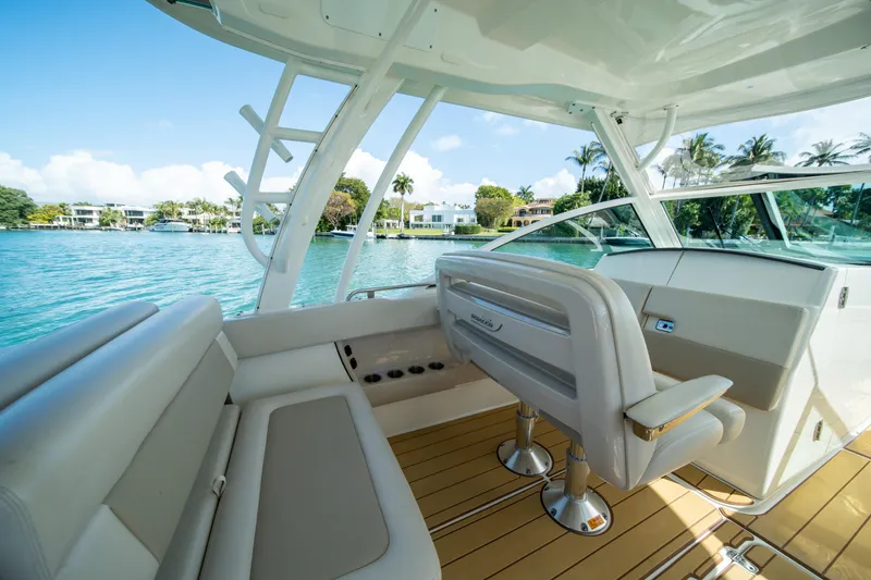 Slide: The Image of 2018 Boston Whaler 320 Vantage boat interior with luxurious seating and scenic water view. - 18