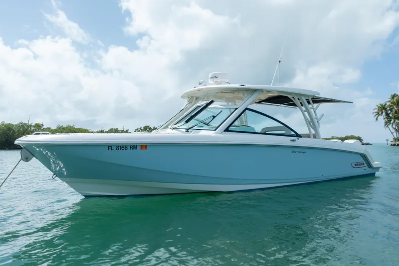 Slide: The Image of 2018 Boston Whaler 320 Vantage boat on calm water under a cloudy sky. - 2