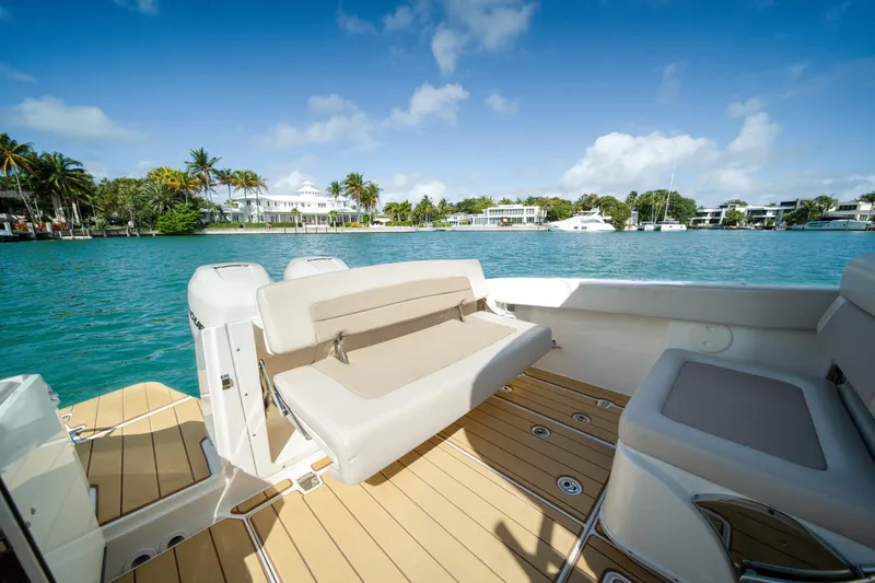 Slide: The Image of 2018 Boston Whaler 320 Vantage boat with seating, docked near waterfront homes. - 21