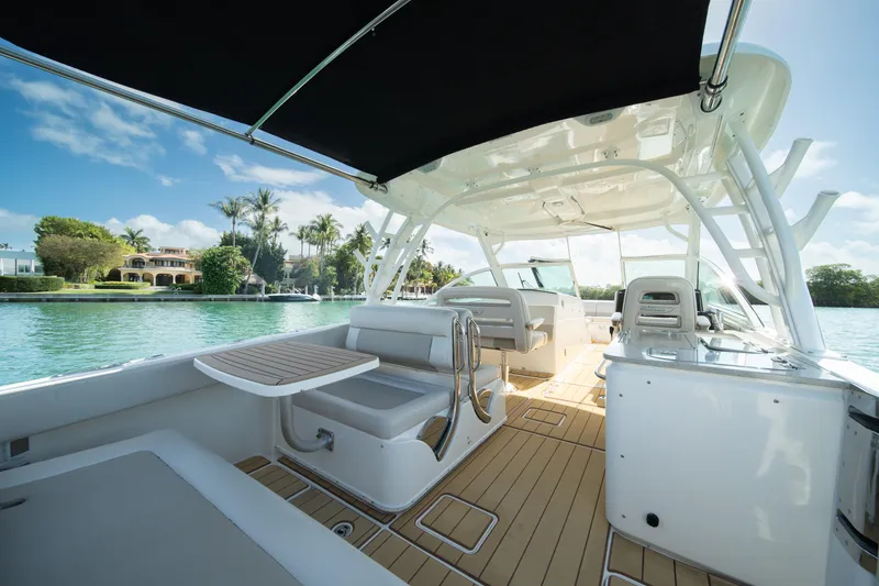 Slide: The Image of 2018 Boston Whaler 320 Vantage boat interior with seating and table, on a sunny day. - 25