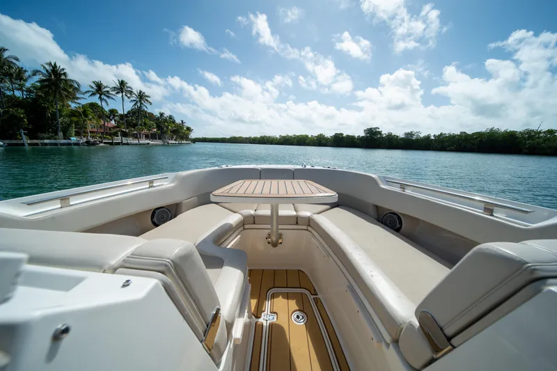 Slide: The Image of 2018 Boston Whaler 320 Vantage boat interior with seating and table, on a sunny day. - 28