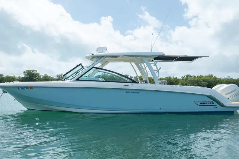 Slide: The Image of 2018 Boston Whaler 320 Vantage boat on calm water under a cloudy sky. - 3