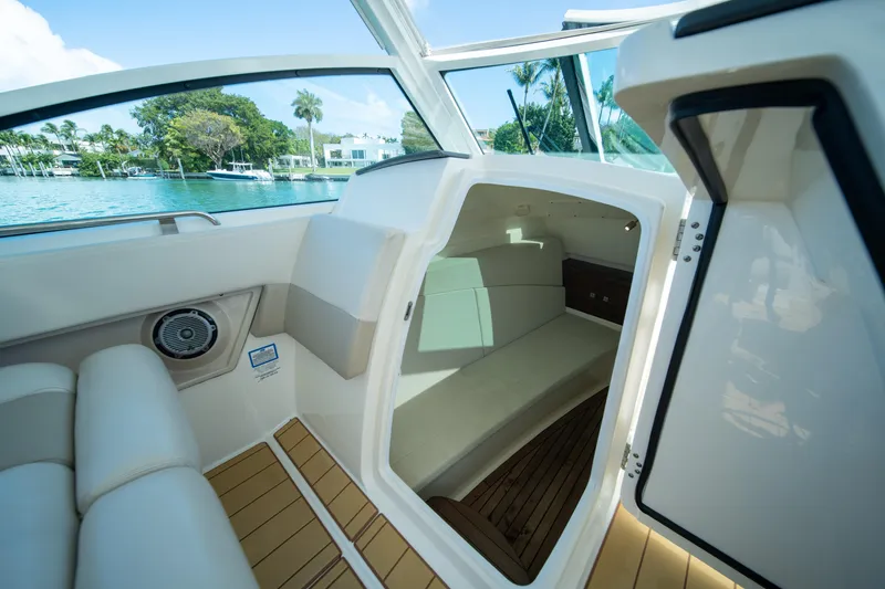 Slide: The Image of Interior view of 2018 Boston Whaler 320 Vantage boat cabin with seating and open door. - 31