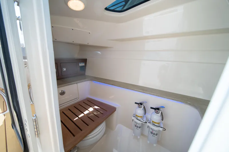 Slide: The Image of Interior of 2018 Boston Whaler 320 Vantage boat with wooden seat and fire extinguishers. - 33