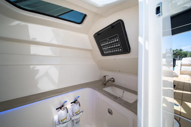 Slide: The Image of 2018 Boston Whaler 320 Vantage interior with sink, control panel, and fire extinguishers. - 34