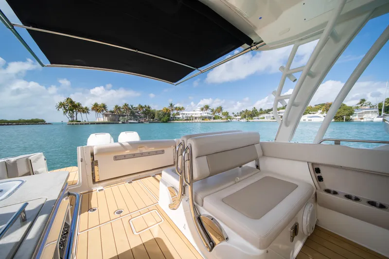 Slide: The Image of 2018 Boston Whaler 320 Vantage boat interior with ocean view and palm trees. - 35