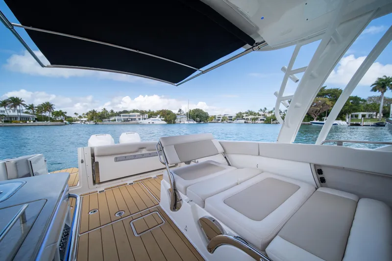 Slide: The Image of 2018 Boston Whaler 320 Vantage boat interior with luxurious seating and scenic waterfront view. - 36