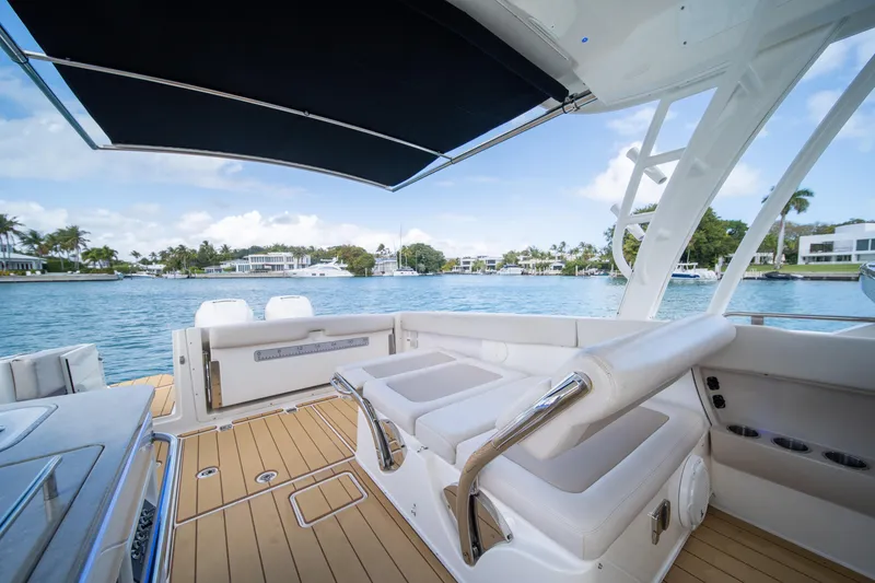 Slide: The Image of 2018 Boston Whaler 320 Vantage boat interior with seating, overlooking serene waterfront homes. - 38