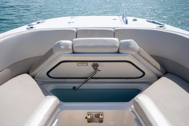 Slide: The Image of 2018 Boston Whaler 320 Vantage boat interior with open storage compartment, on calm water. - 40