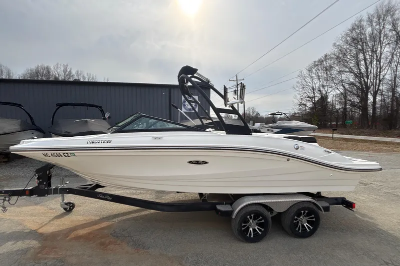 The Image of 2023 Sea Ray SPX 210 boat on trailer, parked outdoors under cloudy sky. - 0