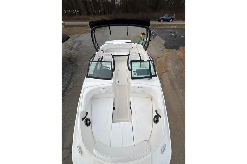 Slide: The Image of 2023 Sea Ray SPX 210 boat with open deck and seating, parked on pavement. - 16