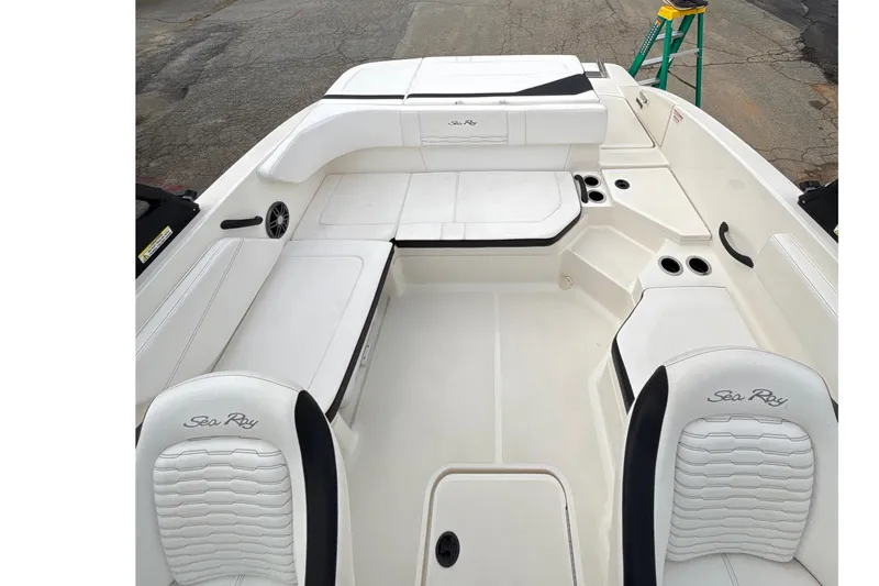 Slide: The Image of 2023 Sea Ray SPX 210 boat interior with white seating and cup holders. - 23