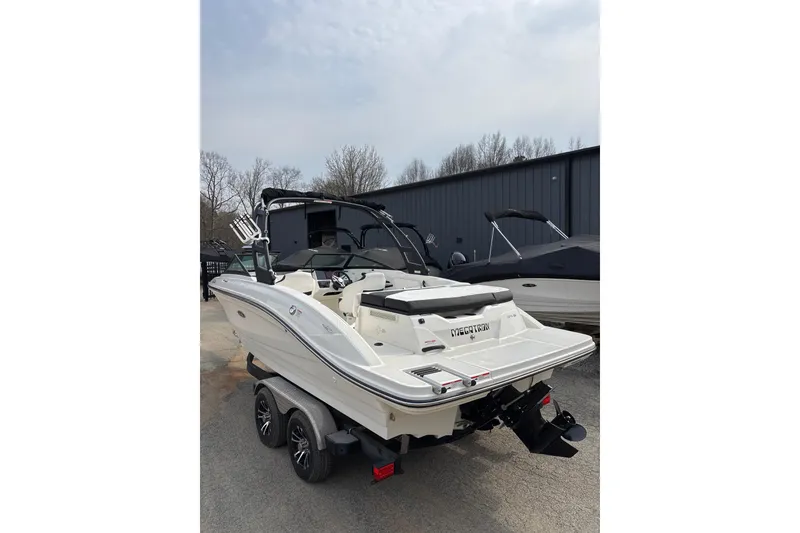Slide: The Image of 2023 Sea Ray SPX 210 boat on trailer, parked outdoors near other boats. - 4