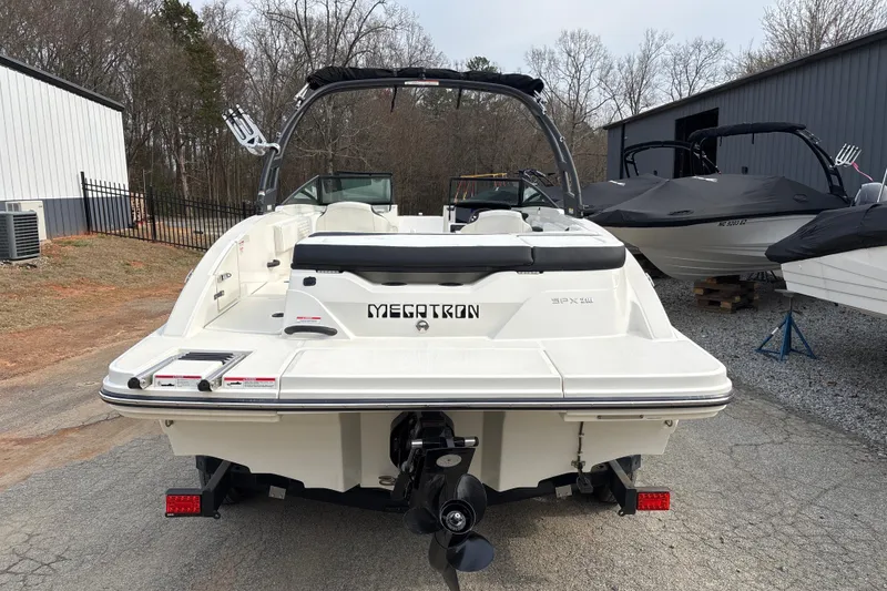 Slide: The Image of 2023 Sea Ray SPX 210 boat, rear view, parked outdoors on a paved surface. - 6