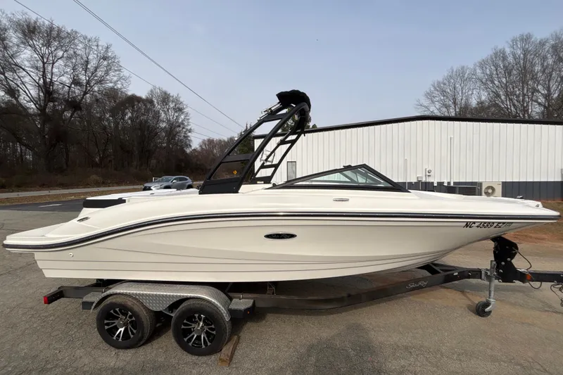 Slide: The Image of 2023 Sea Ray SPX 210 boat on trailer, parked outdoors near a building. - 8
