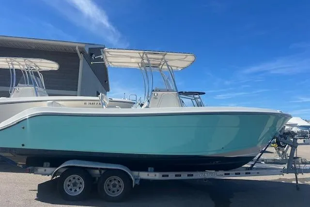 The Image of 2021 Cobia 237 Center Console boat on trailer under clear blue sky. - 0