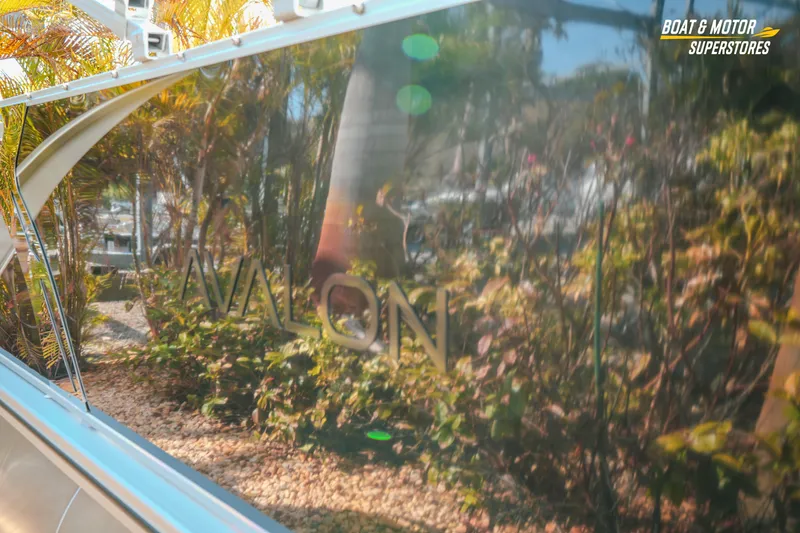 Slide: The Image of 2026 Avalon LSZ Rear Fish boat reflecting lush greenery and sunlight. - 11