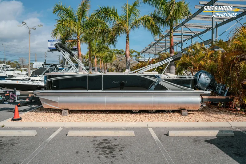 The Image of 2026 Avalon LSZ Rear Fish boat displayed at dealership with palm trees in background. - 2
