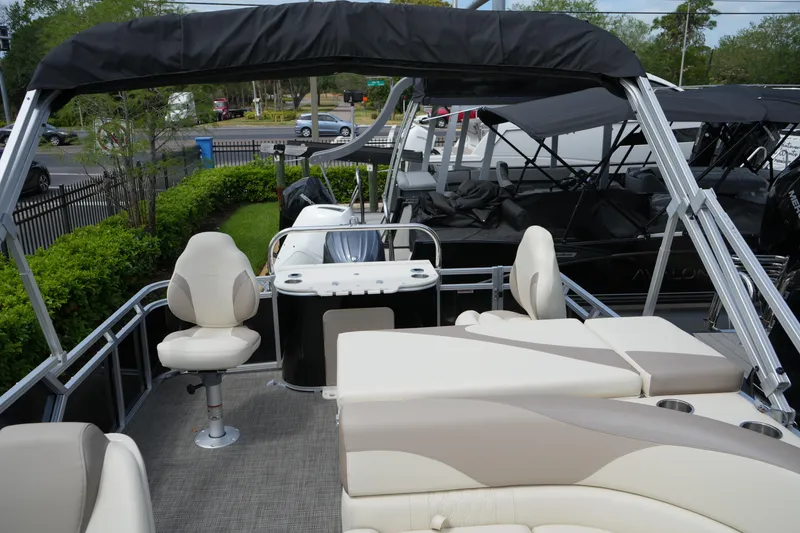 Slide: The Image of 2026 Avalon LSZ Rear Fish 23' pontoon boat with seating and canopy in a showroom. - 39