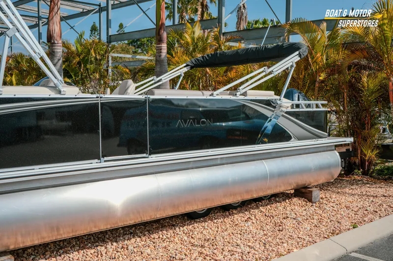 Slide: The Image of 2026 Avalon LSZ Rear Fish pontoon boat displayed outdoors with palm trees. - 4