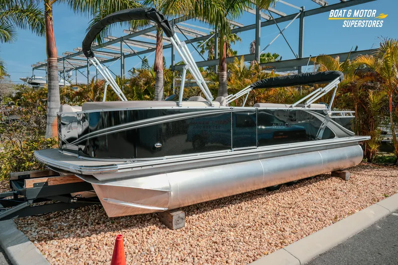 Slide: The Image of 2026 Avalon LSZ Rear Fish 23' pontoon boat displayed outdoors with palm trees. - 5