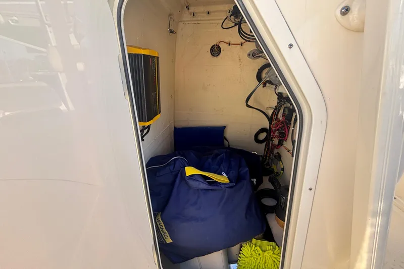 Slide: The Image of 2022 Scout 195 Sportfish storage compartment with equipment and wiring. - 14
