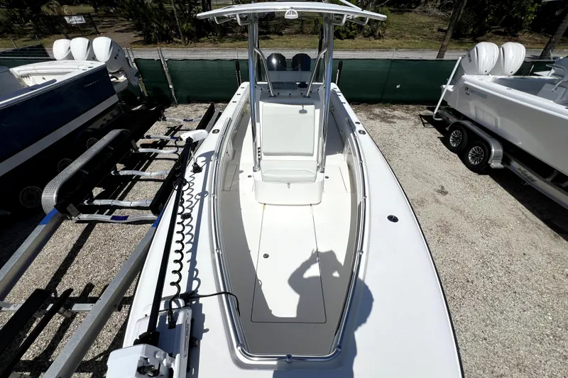 Slide: The Image of 2025 Contender 25 Tournament boat, top view, parked on gravel with trailers nearby. - 13