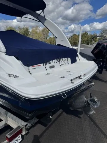 Slide: The Image of 2022 Regal 2000 ES boat on trailer, covered, with outboard motor, under a partly cloudy sky. - 2