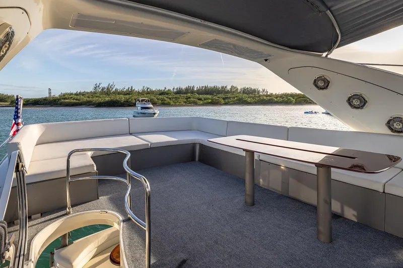 Slide: The Image of Luxurious 2003 Azimut Fly 68 yacht deck with seating, table, and scenic water view. - 11