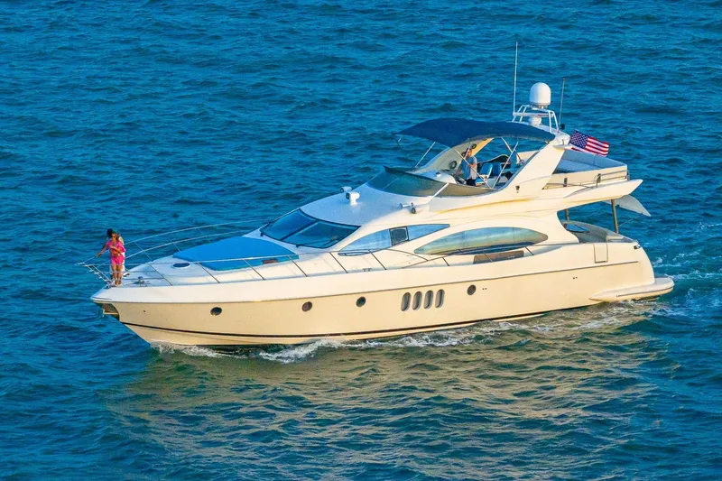 Slide: The Image of Azimut Fly 68 yacht cruising on open water, 2003 model, with passengers enjoying the view. - 13