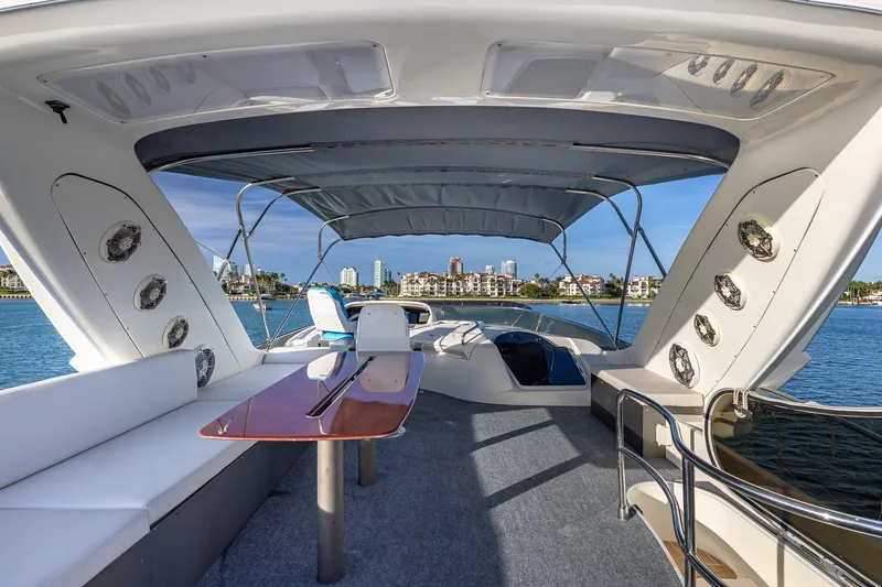 Slide: The Image of Luxurious 2003 Azimut Fly 68 yacht interior with seating and table, overlooking waterfront skyline. - 7