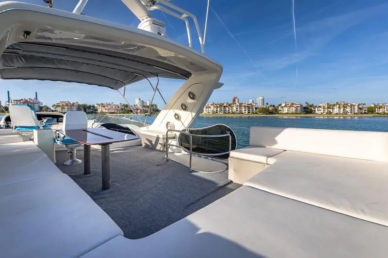 Slide: The Image of Luxurious 2003 Azimut Fly 68 yacht deck with seating, table, and waterfront view. - 8