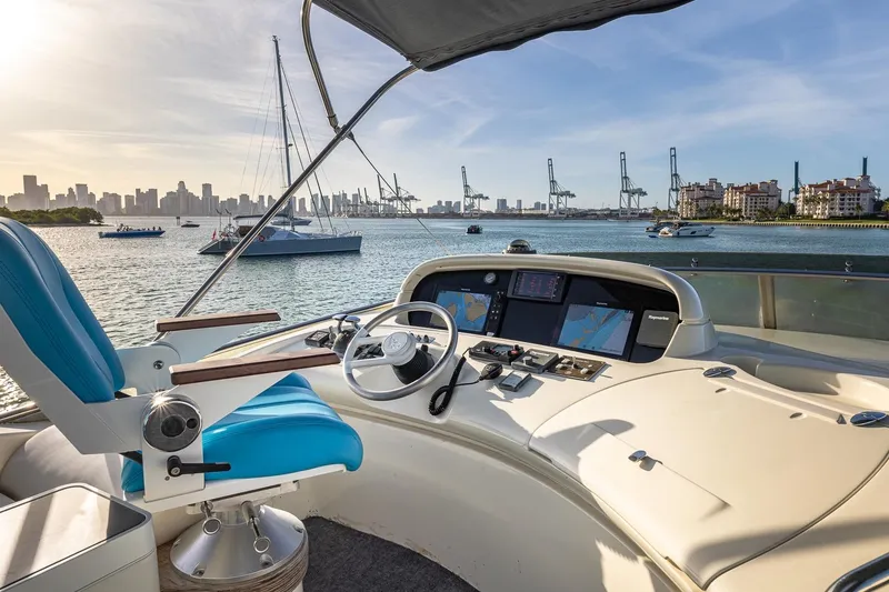 Slide: The Image of Cockpit view of 2003 Azimut Fly 68 yacht with city skyline and harbor. - 9