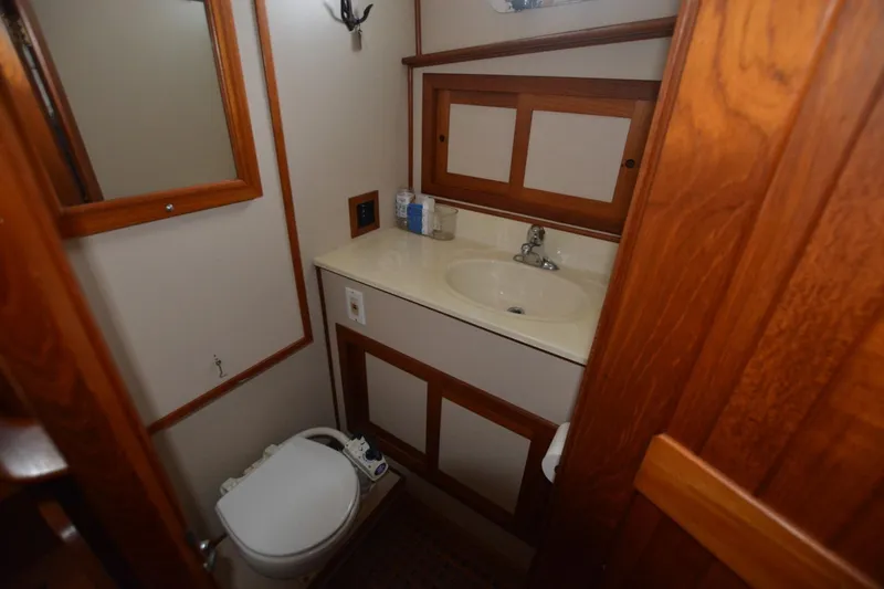 Slide: The Image of 1998 Monk Trawler bathroom with wooden cabinetry, sink, and toilet. - 13