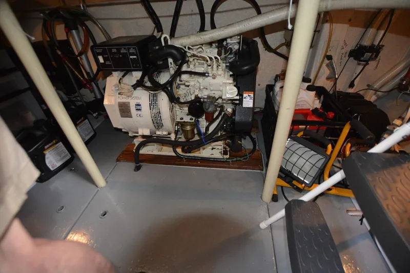 Slide: The Image of Engine room of a 1998 Monk Trawler boat, featuring a generator and equipment. - 18