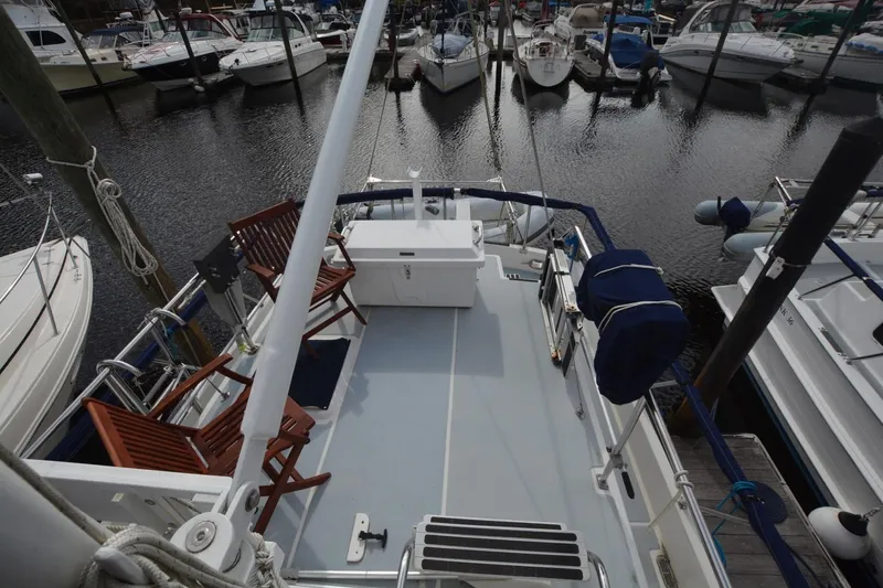 Slide: The Image of 1998 Monk Trawler boat deck with chairs, docked in a marina. - 8