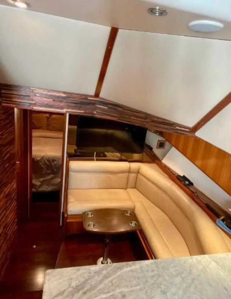 Slide: The Image of Interior of 1994 Viking 38 Convertible yacht with cozy seating and wooden accents. - 4
