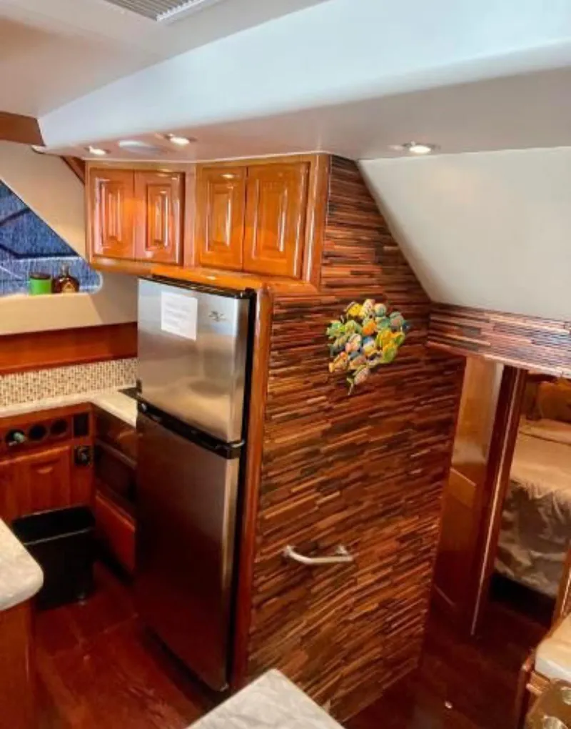 Slide: The Image of 1994 Viking 38 Convertible yacht kitchen with wood cabinets and stainless steel fridge. - 5