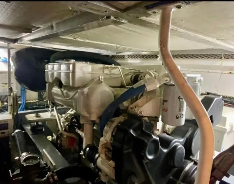 Slide: The Image of Engine room of 1994 Viking 38 Convertible boat, showcasing mechanical components and piping. - 8