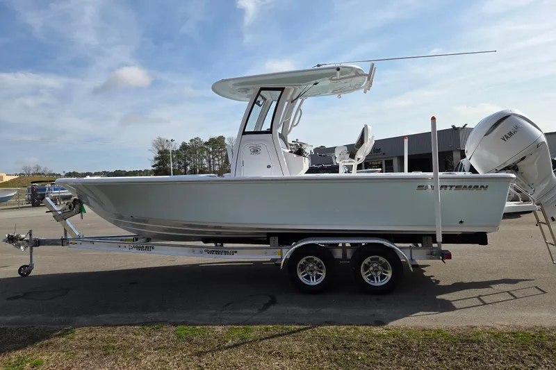 Slide: The Image of 2026 Sportsman Masters 247OE Bay Boat on trailer, parked outdoors under clear sky. - 6