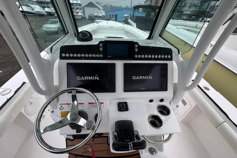 Slide: The Image of 2019 Everglades 273 Center Console boat dashboard with Garmin navigation displays. - 10