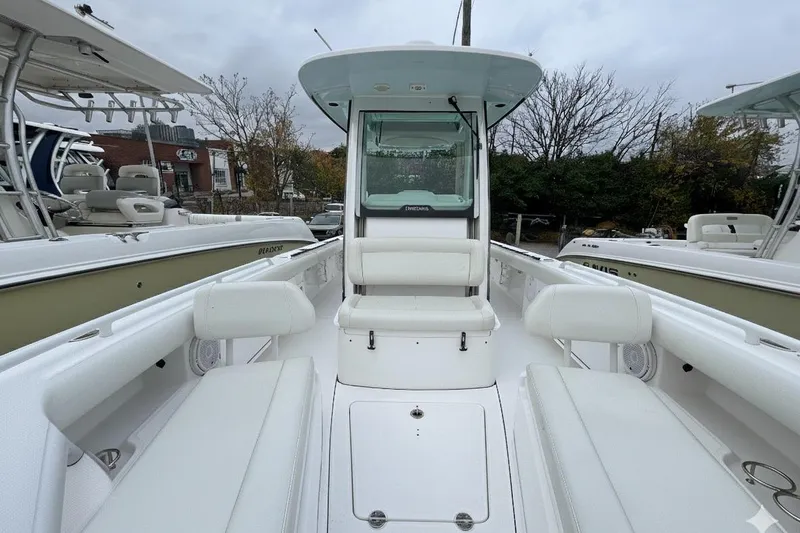 Slide: The Image of 2019 Everglades 273 Center Console boat with white seating and console, docked outdoors. - 13
