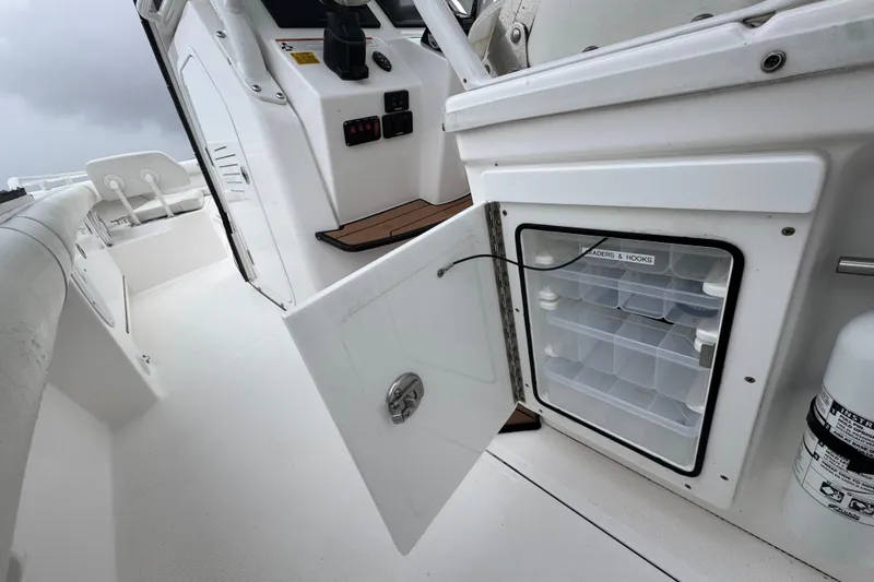 Slide: The Image of 2019 Everglades 273 Center Console boat with open storage compartment and fishing gear organizer. - 14